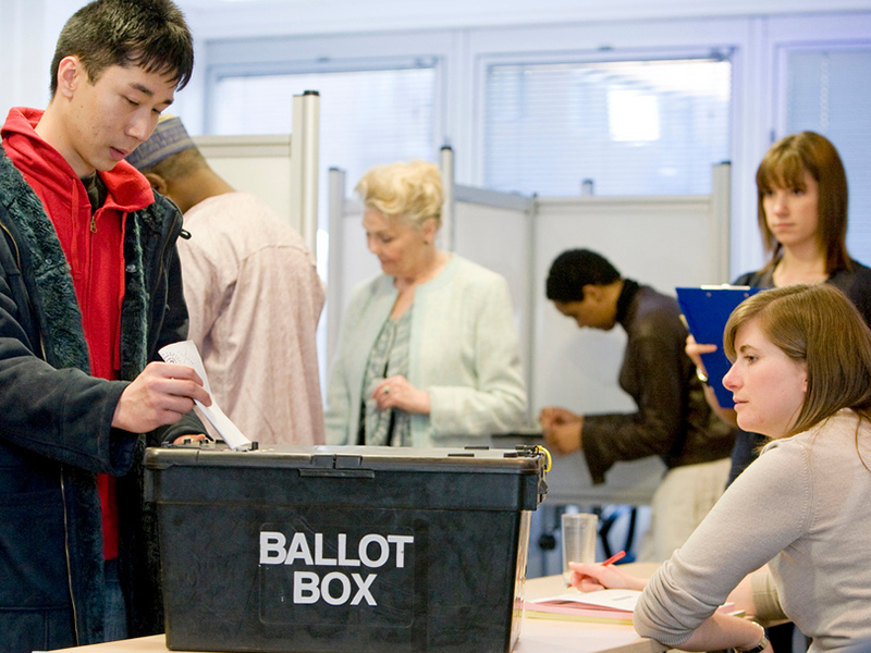 Man placing vote in a ballot box