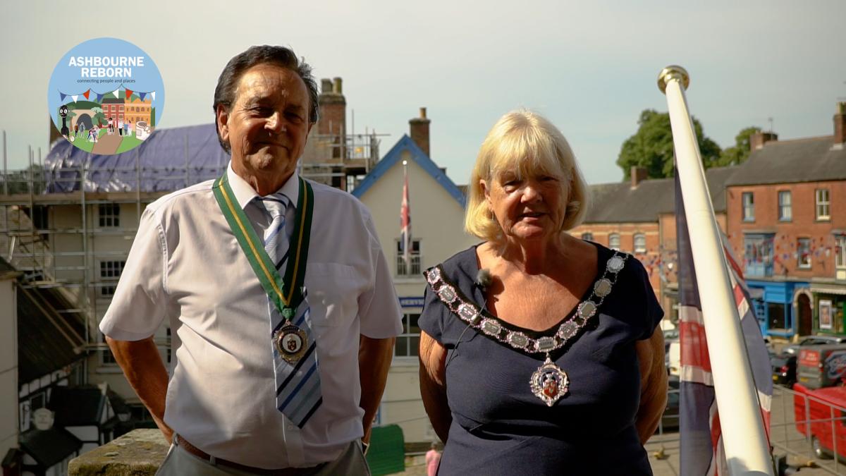 Councillor Sandra Spencer and consort Councillor Martin Spencer wearing their official mayoral chains stand in front of Ashbourne Market Place